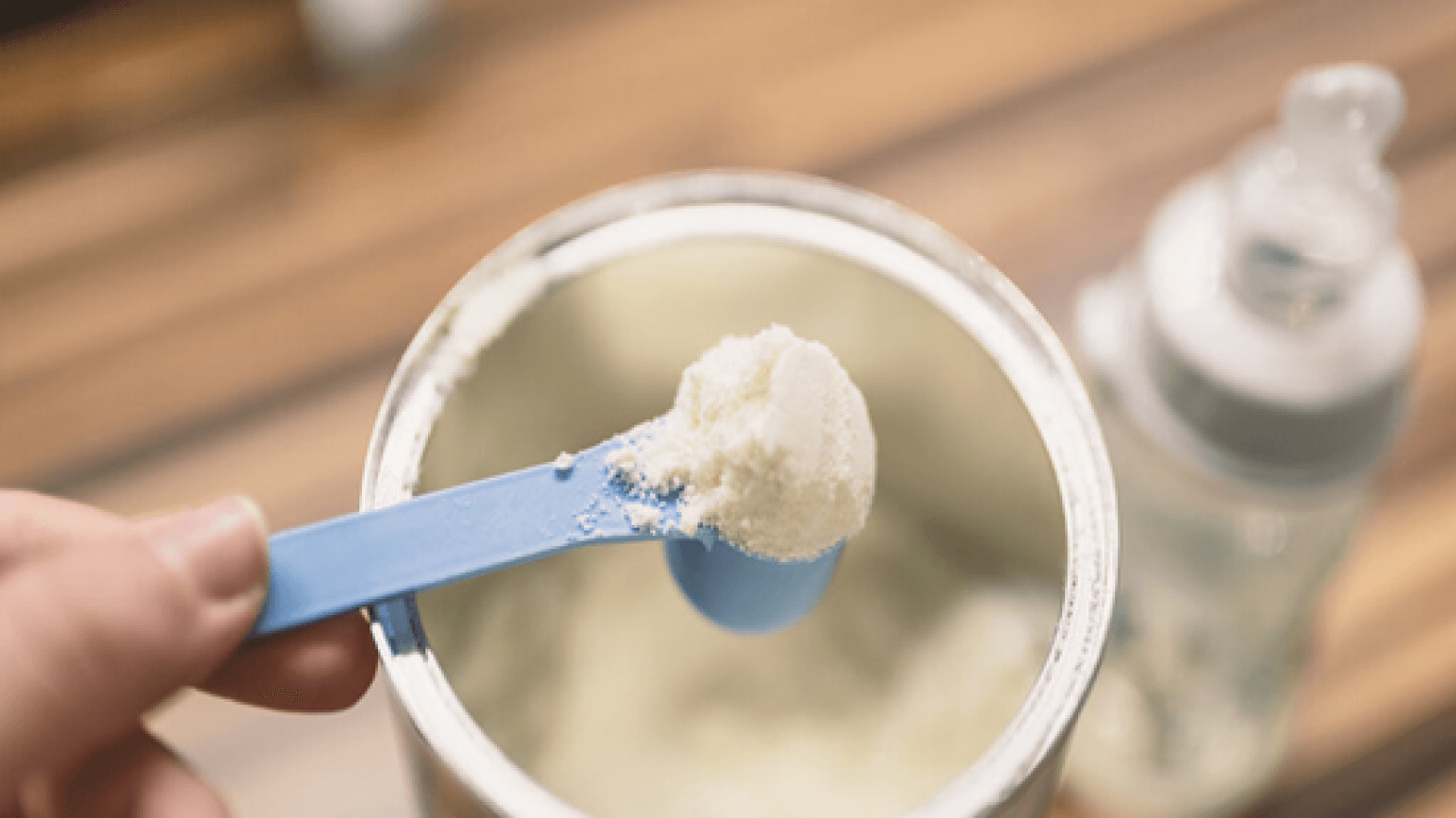 Scooping baby formula powder from a can